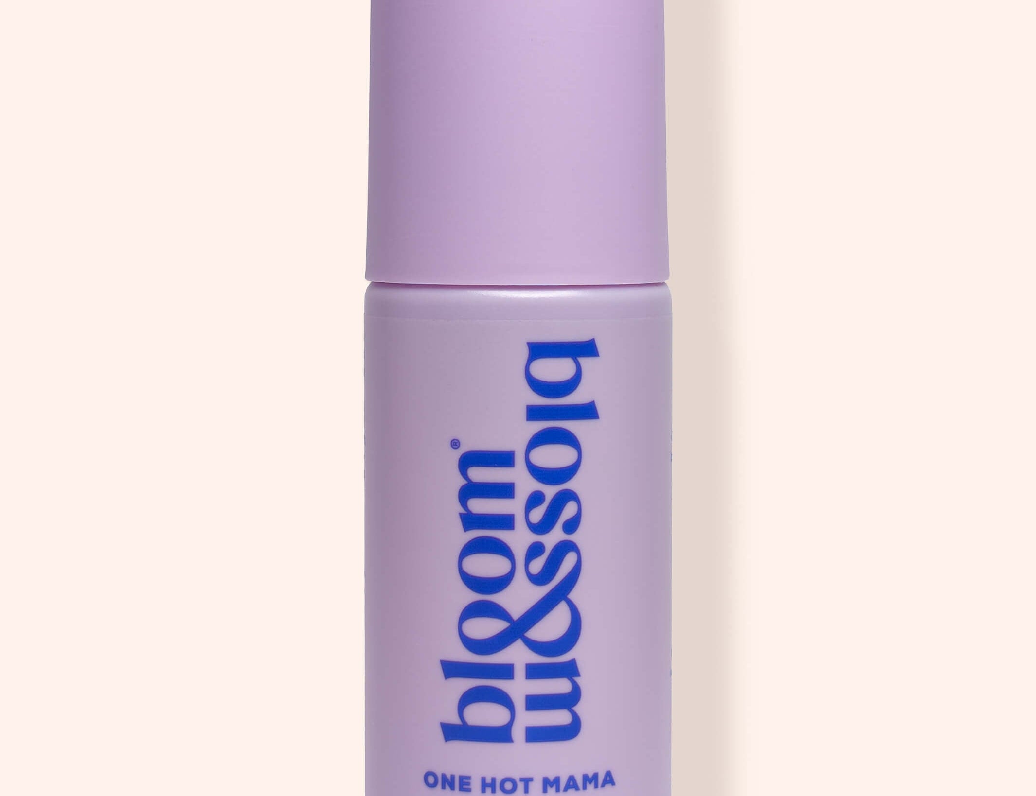 A lavender purple cylindrical bottle of bloom & soho One Hot Mama Revitalising Face & Body Mist, shown against a solid pale peach background.