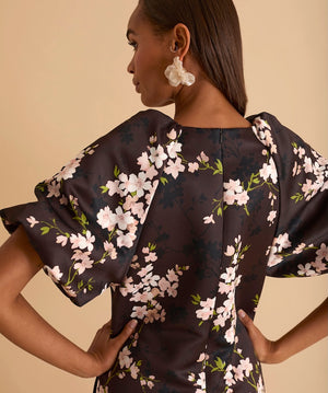 Model wearing floral puff sleeve tiered midi dress in chocolate blossom print.