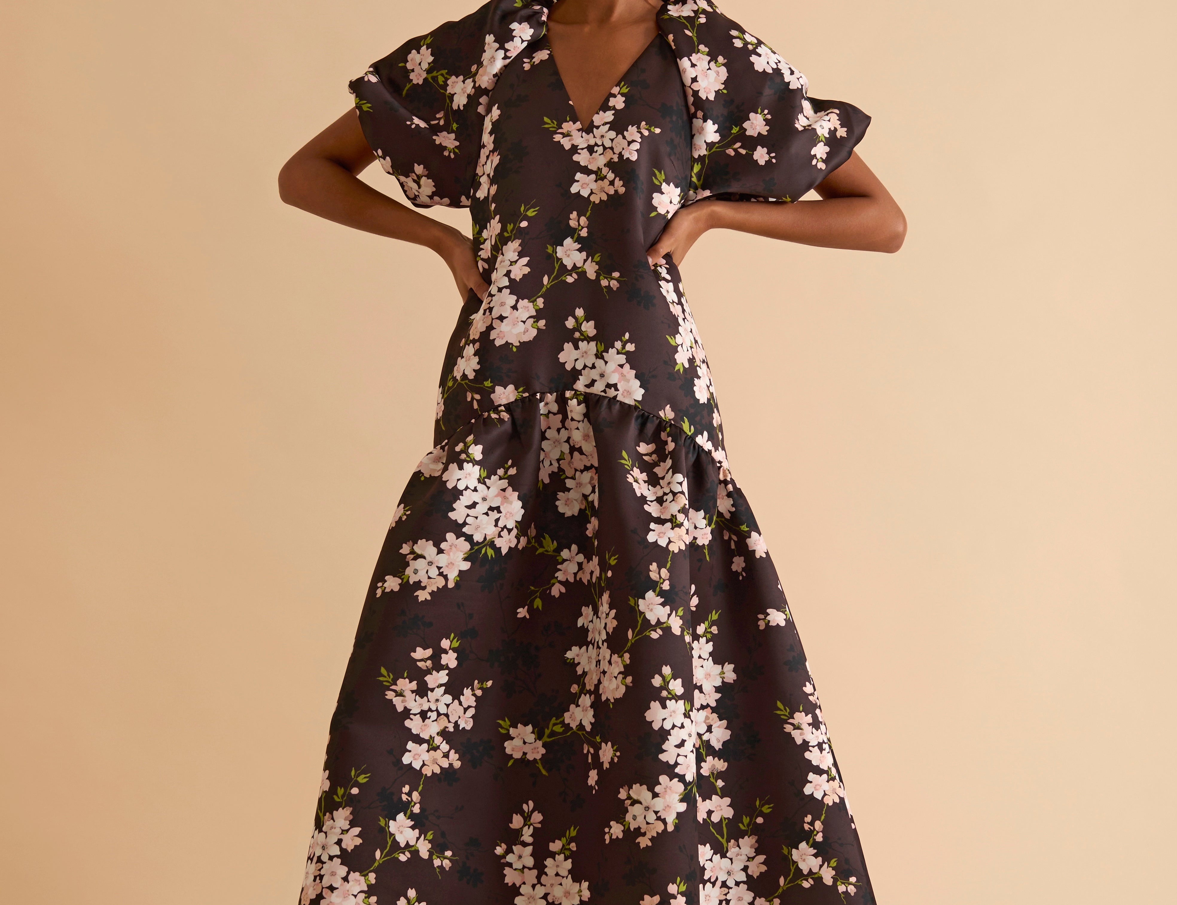 Model wearing floral puff sleeve tiered midi dress in chocolate blossom print.