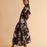 Model wearing floral puff sleeve tiered midi dress in chocolate blossom print.