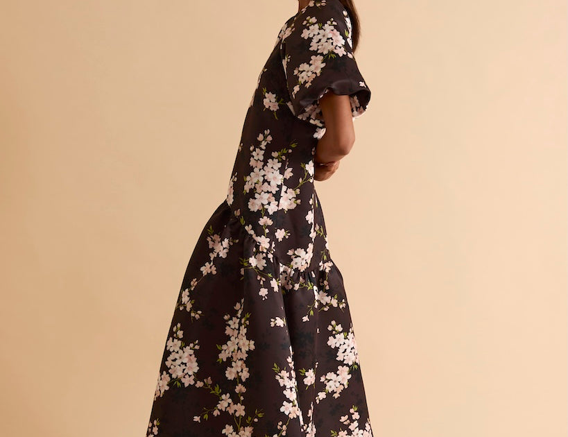 Model wearing floral puff sleeve tiered midi dress in chocolate blossom print.