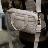 Neutral quilted baby changing bag by Ralphie Bear with waterproof lining, zip compartments, and adjustable strap.