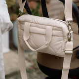 Neutral quilted baby changing bag by Ralphie Bear with waterproof lining, zip compartments, and adjustable strap.