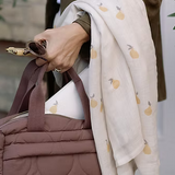 Neutral quilted baby changing bag by Ralphie Bear with waterproof lining, zip compartments, and adjustable strap.