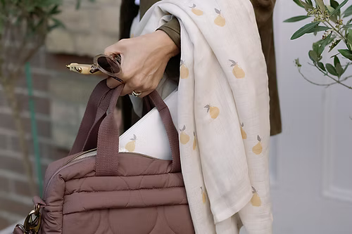 Neutral quilted baby changing bag by Ralphie Bear with waterproof lining, zip compartments, and adjustable strap.