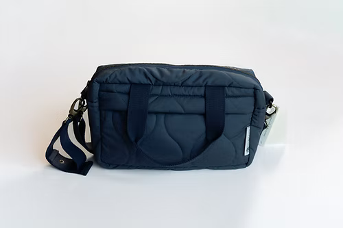 Navy blue bag with a strap on a white background