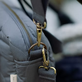 Gray bag with gold zipper and strap details