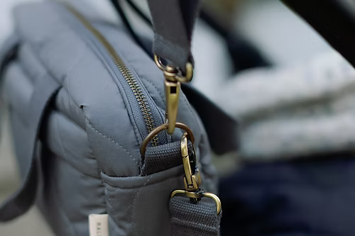 Gray bag with gold zipper and strap details