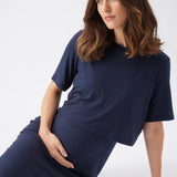 Woman wearing a navy blue dress sitting on a white background