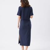 Woman wearing a navy blue outfit with a skirt on a white background