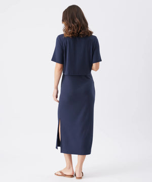 Woman wearing a navy blue outfit with a skirt on a white background