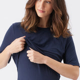 Woman wearing a navy blue ribbed dress against a white background