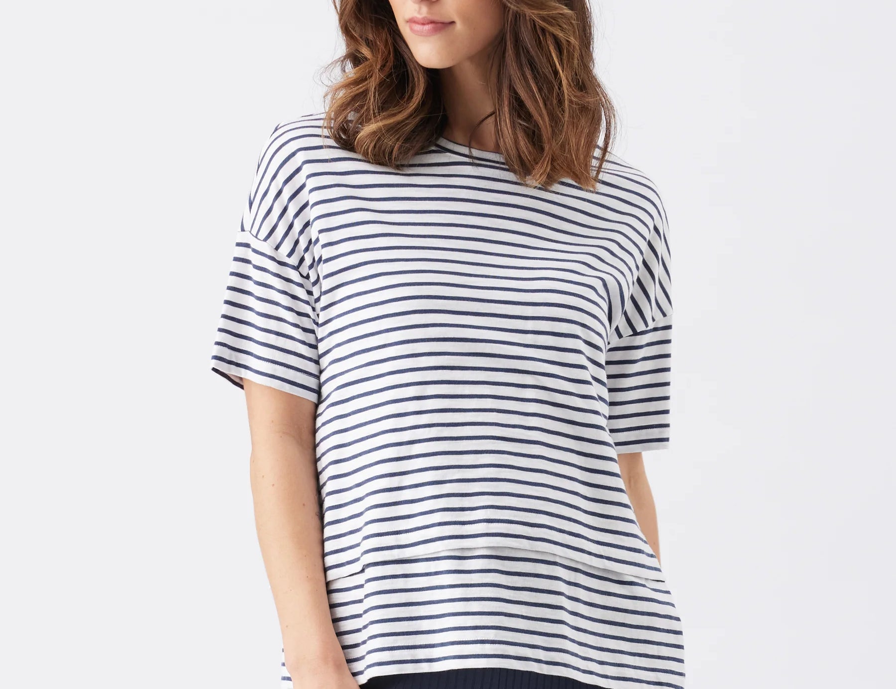 Woman wearing a navy and white striped shirt on a white background