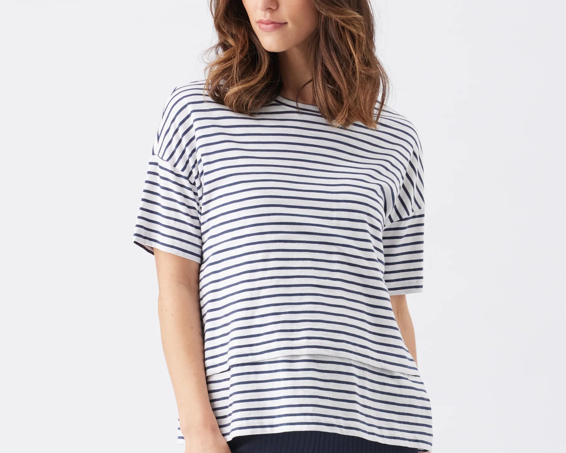 Woman wearing a navy and white striped shirt on a white background