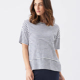 Woman wearing a navy and white striped shirt on a white background