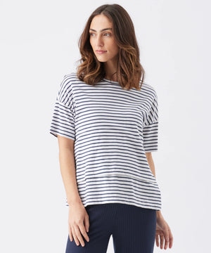 Woman wearing a navy and white striped shirt on a white background