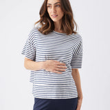 Woman wearing a navy and white striped shirt with navy pants on a white background