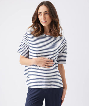 Woman wearing a navy and white striped shirt with navy pants on a white background