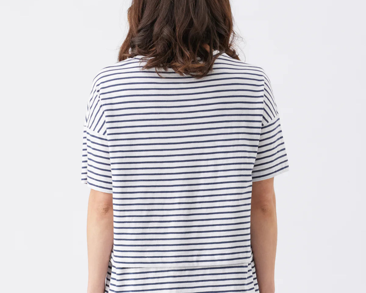 Person wearing a navy and white striped shirt on a plain background