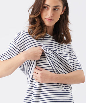 Woman wearing a navy and white striped shirt on a plain background