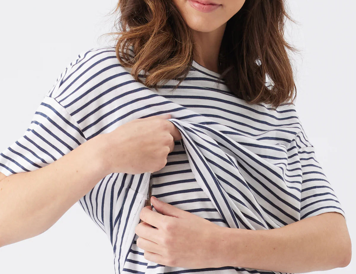 Woman wearing a navy and white striped shirt on a plain background