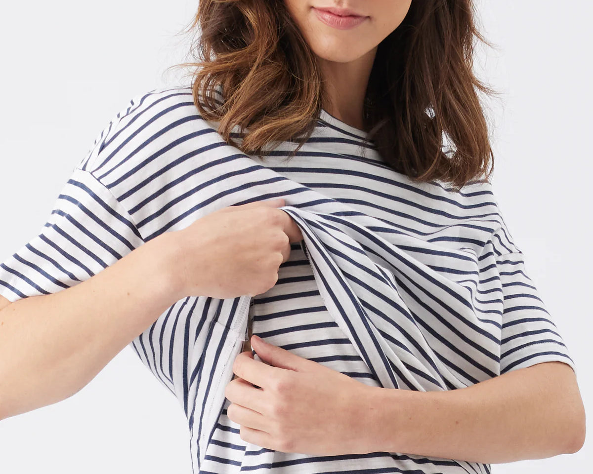 Woman wearing a navy and white striped shirt on a plain background