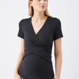 Woman wearing a black wrap-style top with short sleeves on a white background
