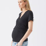 Woman wearing a black top and light blue jeans on a white background