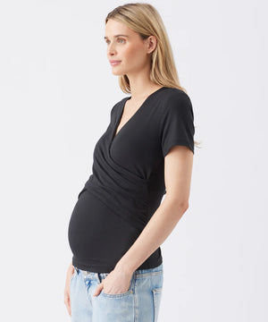 Woman wearing a black top and light blue jeans on a white background