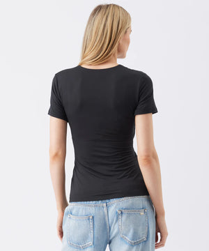 Person wearing a black t-shirt and light blue jeans on a white background