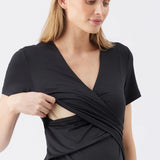 Woman wearing a black wrap dress on a light gray background