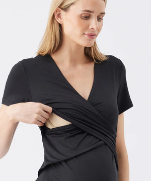 Woman wearing a black wrap dress on a light gray background