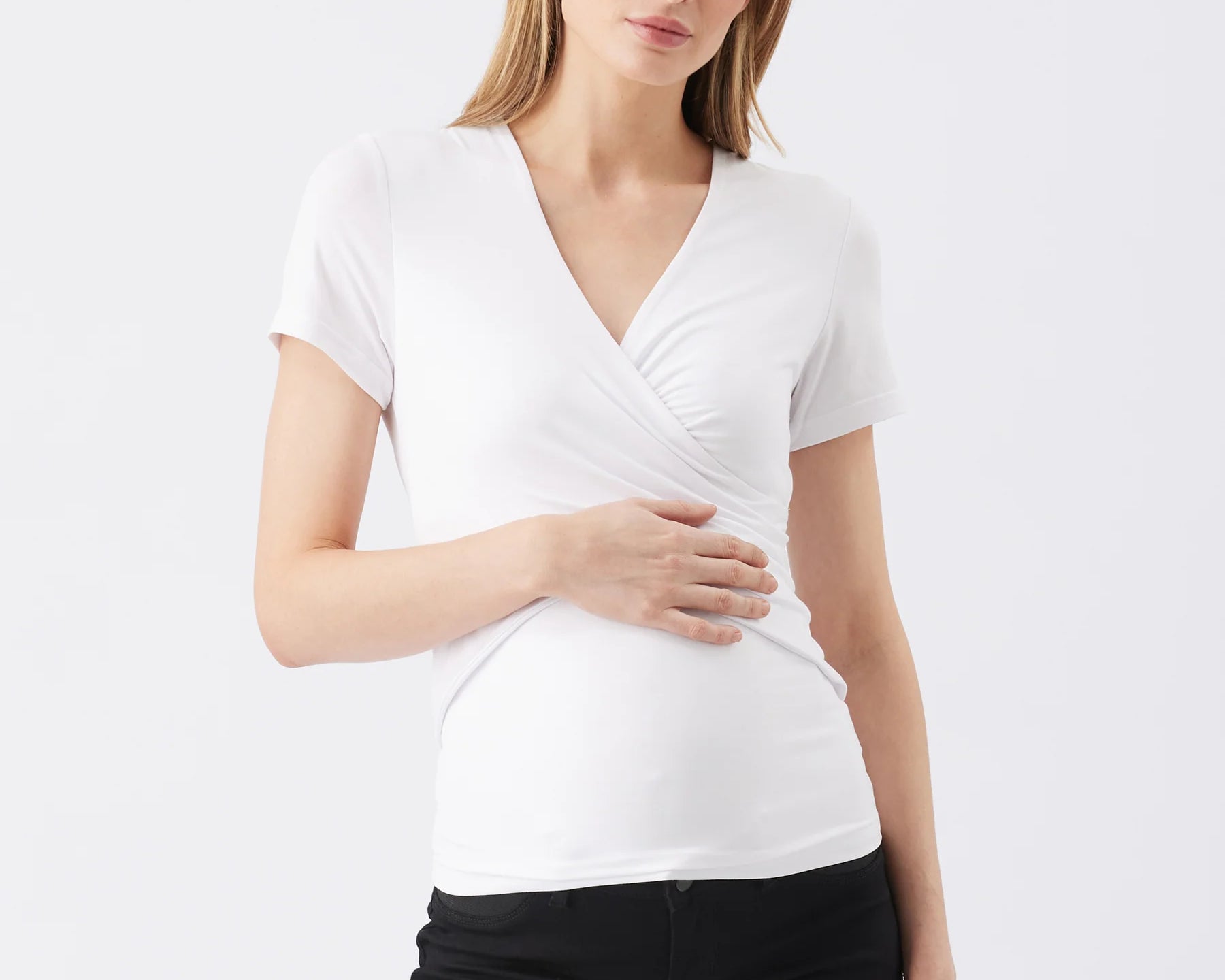 Woman wearing a white short-sleeve top and black pants on a white background