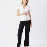 Woman wearing a white top and black pants on a white background