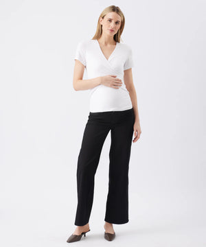 Woman wearing a white top and black pants on a white background