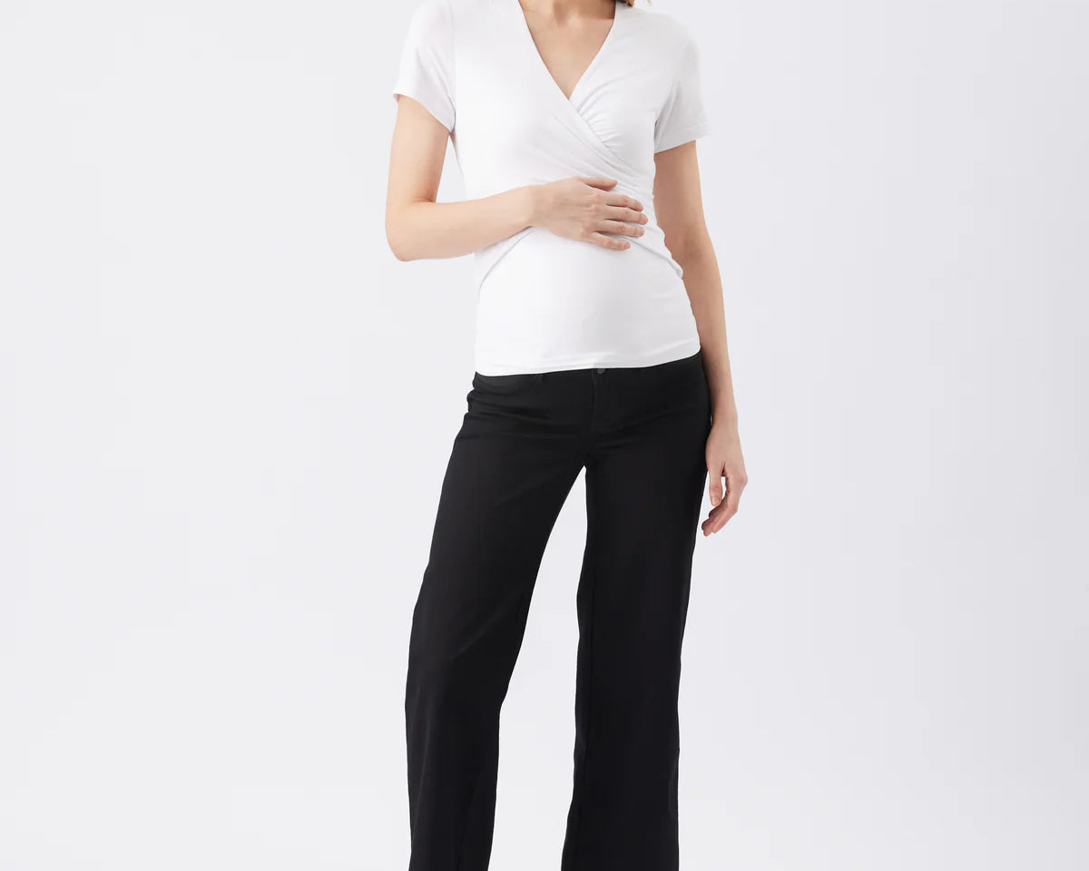 Woman wearing a white top and black pants on a white background
