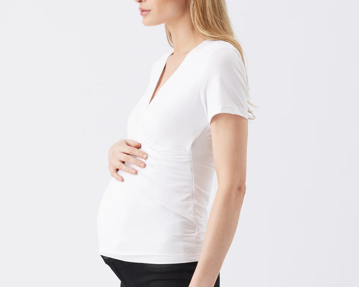 Woman wearing a white V-neck top on a plain background