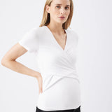 Woman wearing a white wrap top with a plain background
