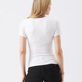 Woman wearing a white t-shirt and black pants on a white background
