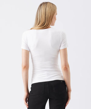 Woman wearing a white t-shirt and black pants on a white background