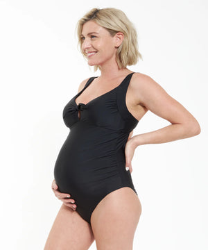 Woman wearing a black maternity swimsuit on a white background