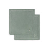 Two green placemats with a brand logo on a white background