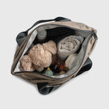 Sigrid Eco Changing Bag in Mocha open from above, showing a soft toy, muslin, nappy, bottle and dummies inside