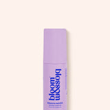 A lavender purple cosmetic tube for 'bloom & assolo' Smooth Moves Smooth Mark Gel, shown on a solid pale cream background.