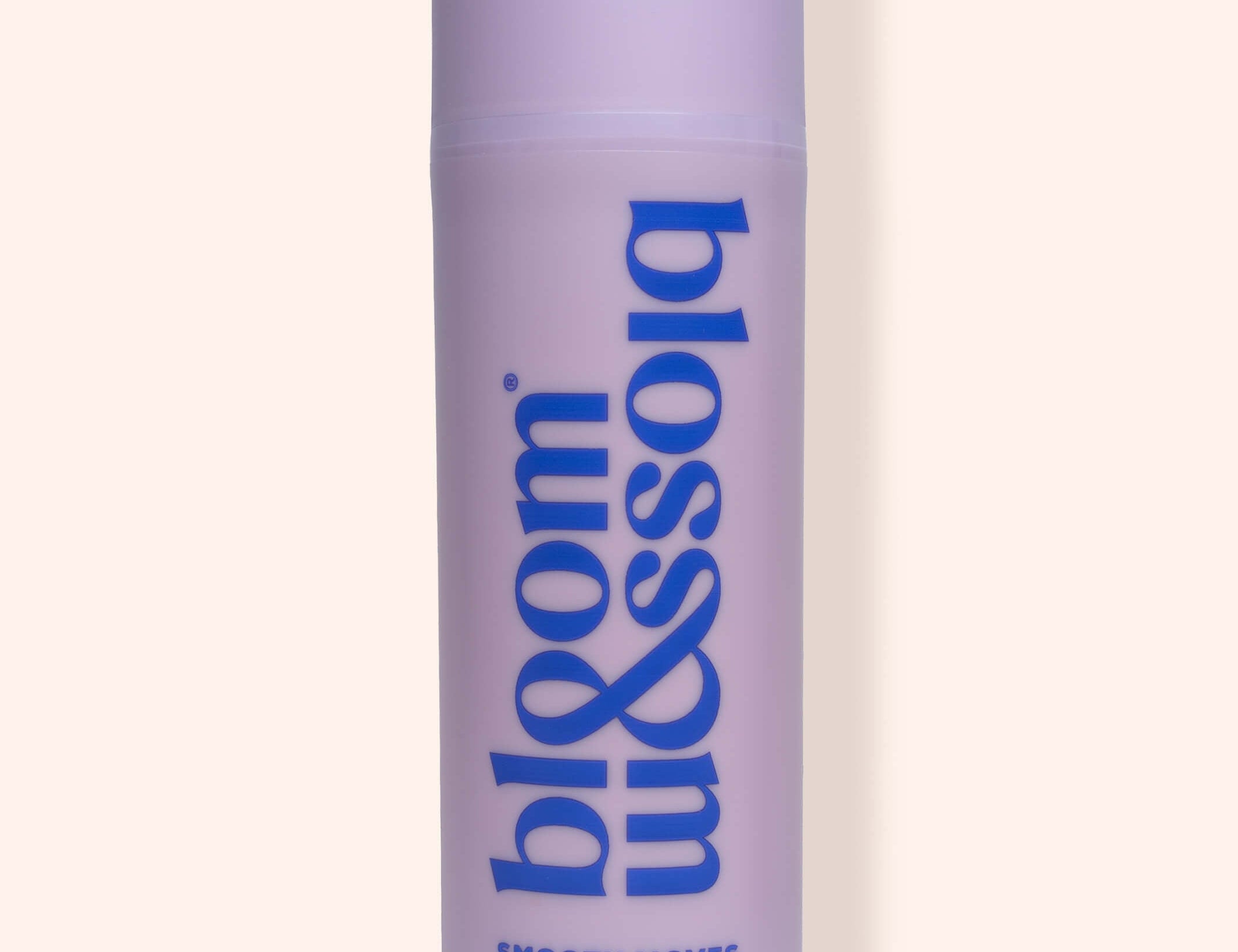 A lavender purple cylindrical bottle of bloom & soia Stretch mark oil, featuring blue text, set against a solid pale beige background with a soft shadow.