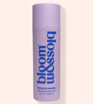 A lavender purple cylindrical bottle of bloom & soia Stretch mark oil, featuring blue text, set against a solid pale beige background with a soft shadow.