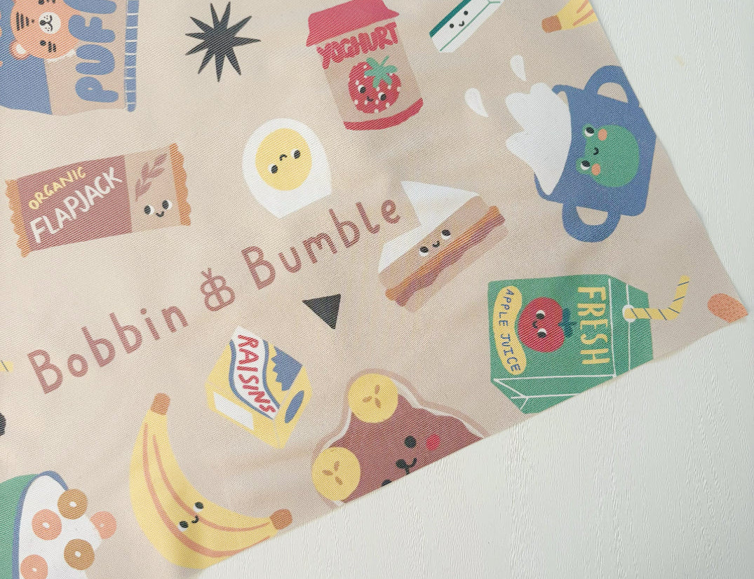Splash Mat Snack Time, close-up of a corner showing the snack characters pattern and Bobbin and Bumble name on beige