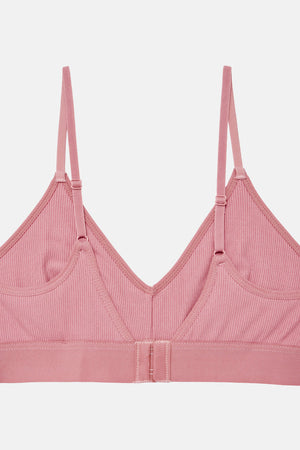 A pink ribbed wireless bralette with thin adjustable shoulder straps and a wide underband, shown flat against a light gray background.