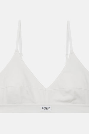 A white wireless bralette by RENUE, featuring thin adjustable shoulder straps and a wide underband with the brand name printed in black, shown against a light gray background.