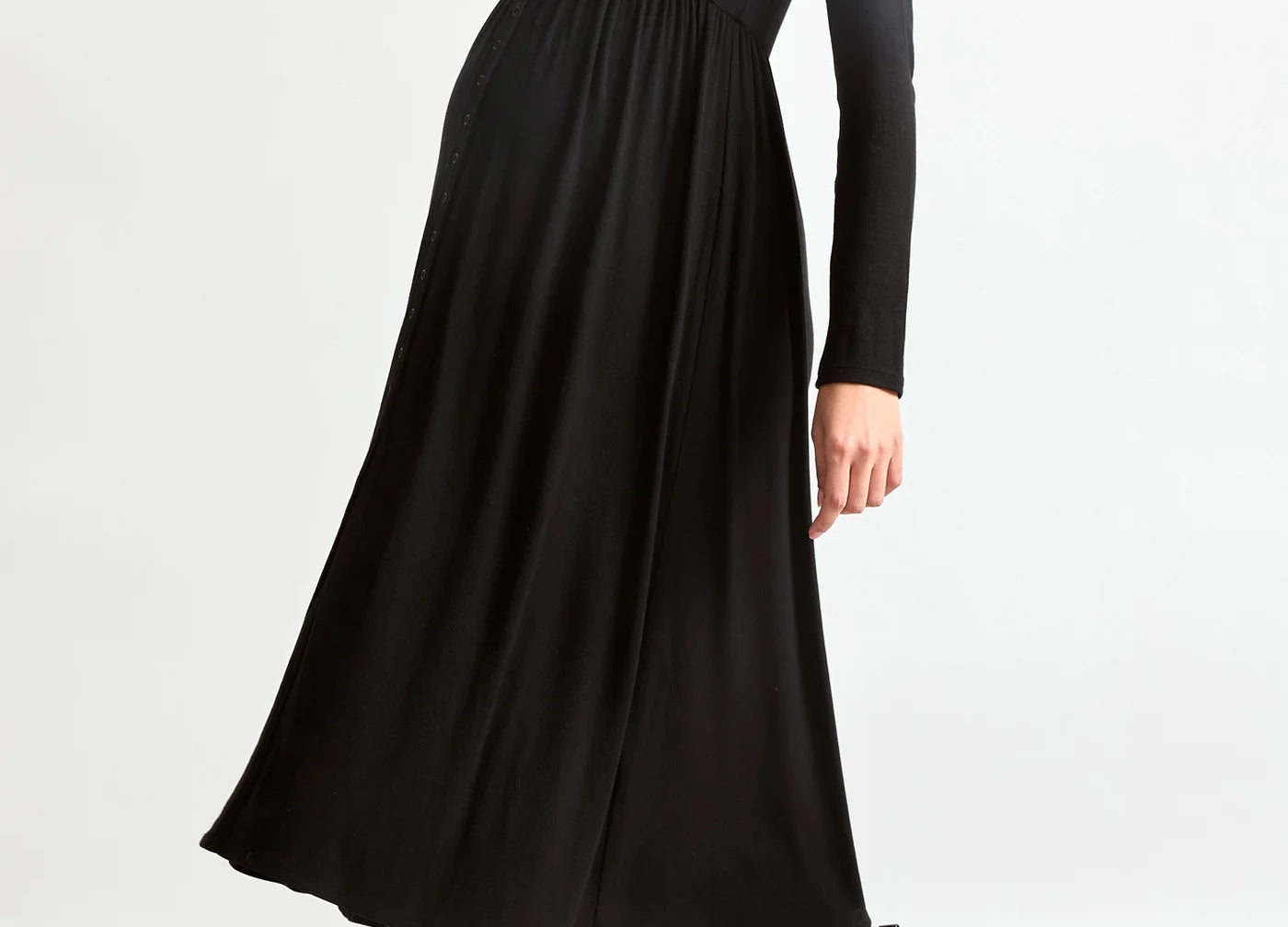 Woman wearing a black dress and black boots on a white background